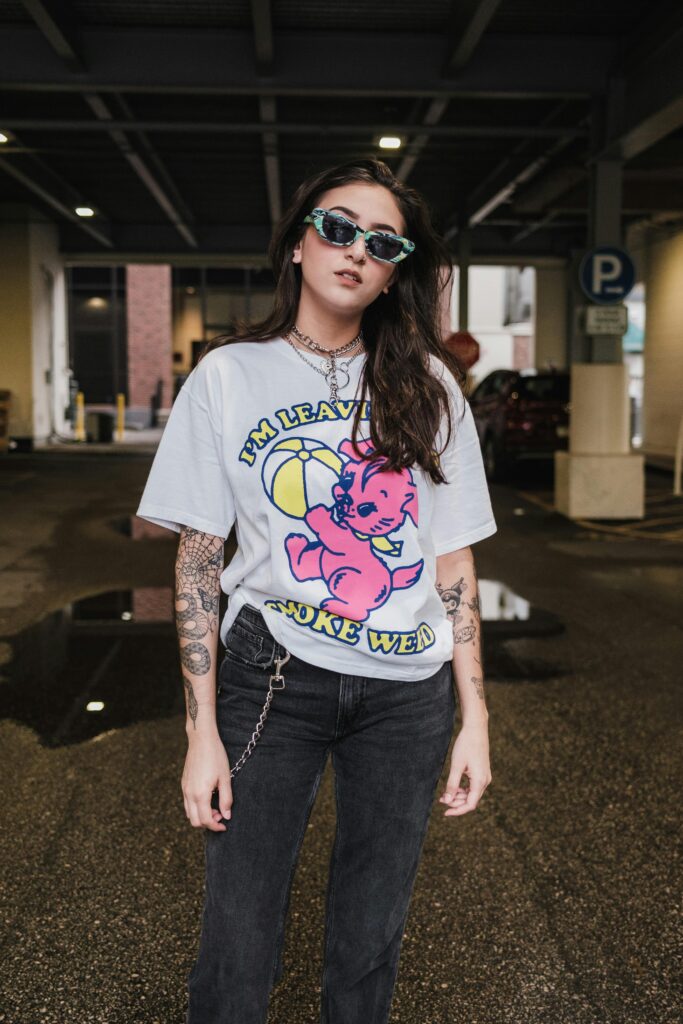 Fashion-forward woman wearing streetwear posing in an urban setting.